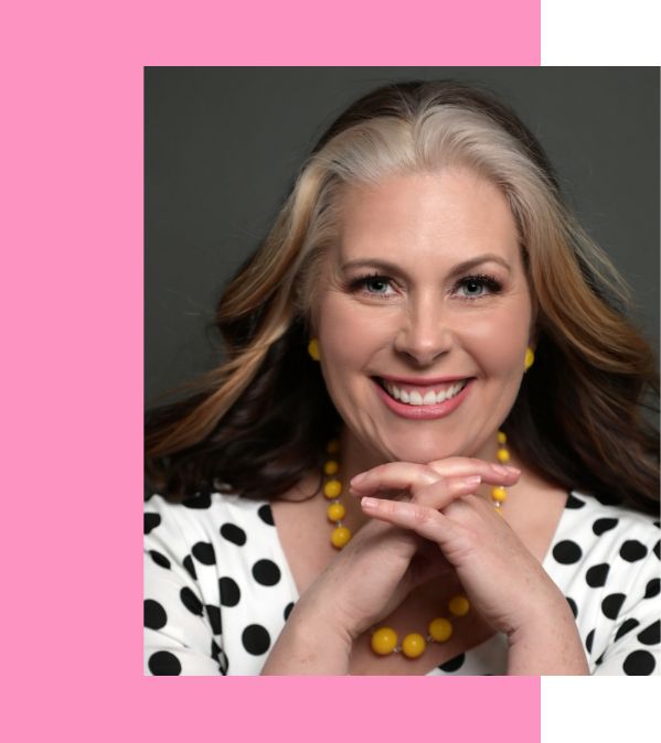 Beautiful woman wearing a polka dot black and white shirt, with her hands crossed and her chin resting on them. In the background a pink square.